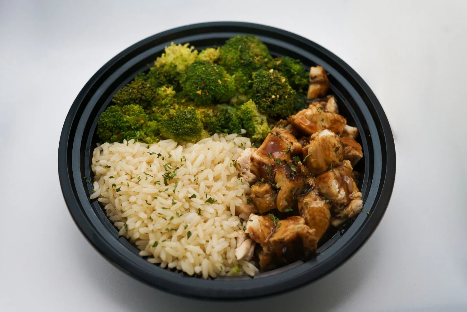 Chicken, rice and colorful vegetables portioned in a meal bowl